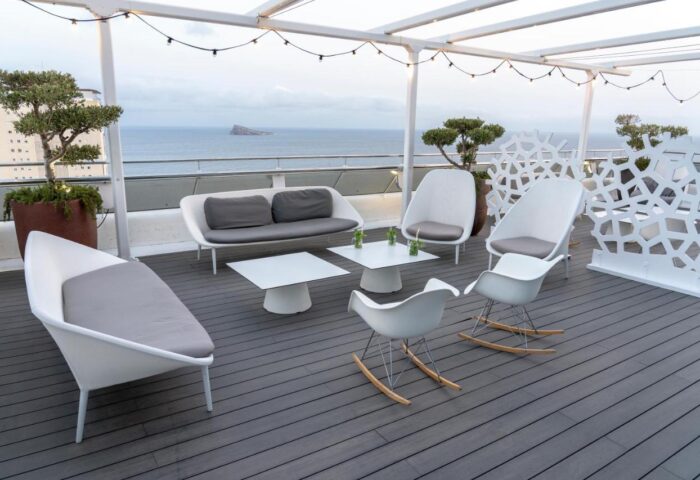 Hotel Madeira Centro's gay-friendly rooftop terrace. White modern furniture, ocean view. Perfect for gay travelers seeking relaxation.
