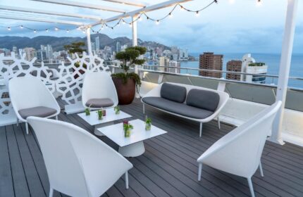 Hotel Madeira Centro gay-friendly rooftop lounge. White chairs & sofa offer city/sea views. A stylish spot for gay travelers in Benidorm.