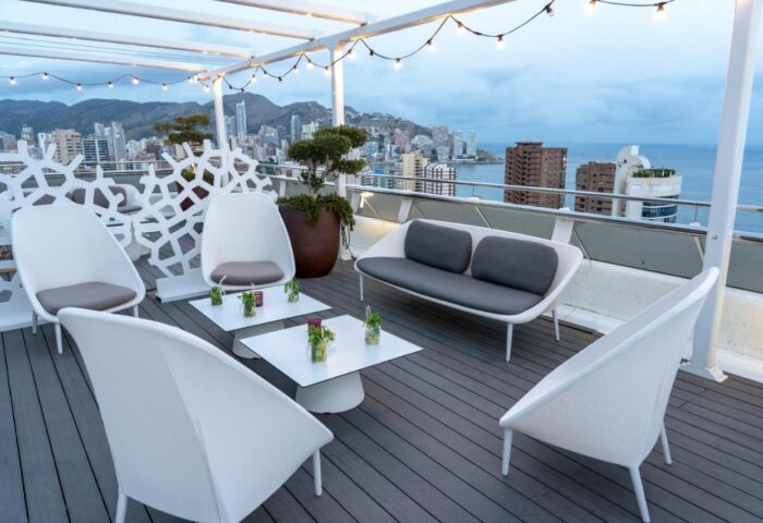 Hotel Madeira Centro gay-friendly rooftop lounge. White chairs & sofa offer city/sea views. A stylish spot for gay travelers in Benidorm.
