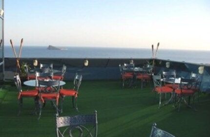 Hotel Madeira Centro's rooftop terrace with ocean view. Gay-friendly hotel with tables and chairs on the top floor.