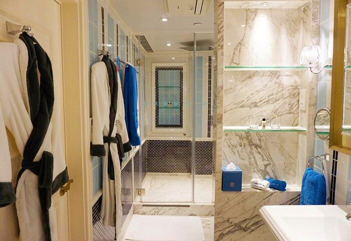 Hotel Madera Hollywood gay-friendly hotel bathroom. Marble walls, glass shelves, robes, towels, and shower. Upscale, luxurious design.
