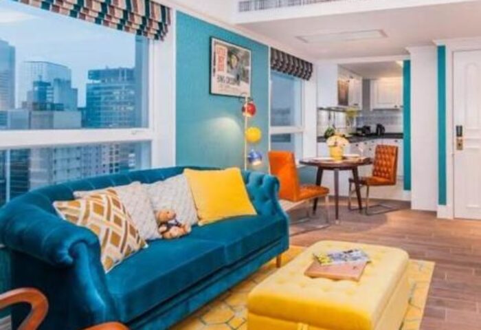 Hotel Madera Hollywood gay-friendly hotel room. Blue sofa, yellow ottoman, and city view. Modern design. Gay travel advice.