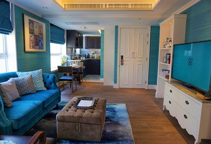Hotel Madera Hollywood gay-friendly hotel suite. Teal walls, blue sofa, kitchen area, TV. Stylish design for gay travelers.