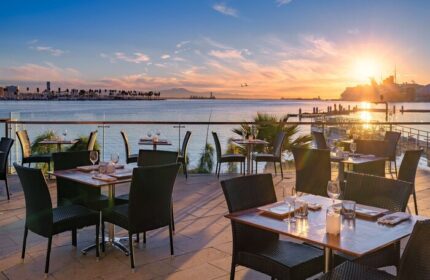 Hotel Maya A Doubletree Hotel's gay-friendly outdoor dining area at sunset. Tables set for dinner overlook the ocean. A romantic spot.
