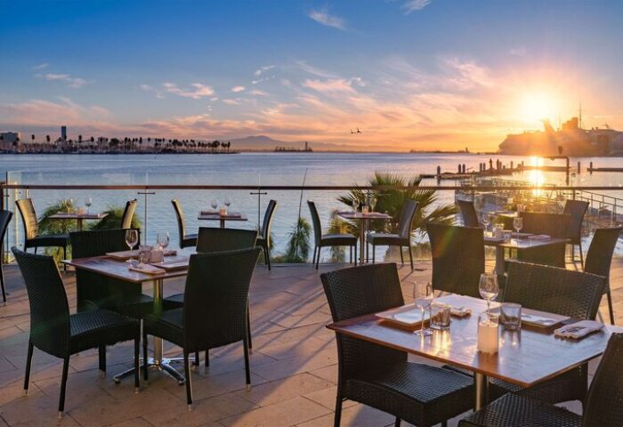 Hotel Maya A Doubletree Hotel's gay-friendly outdoor dining area at sunset. Tables set for dinner overlook the ocean. A romantic spot.