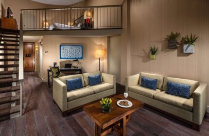 Hotel Maya A Doubletree Hotel suite interior. Gay-friendly hotel room with loft bed, sofas, desk, and modern decor. Ideal for gay travel.