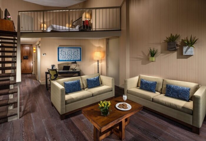 Hotel Maya A Doubletree Hotel suite interior. Gay-friendly hotel room with loft bed, sofas, desk, and modern decor. Ideal for gay travel.