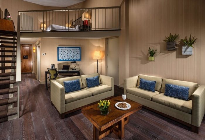 Hotel Maya A Doubletree Hotel suite interior. Gay-friendly hotel room with loft bed, sofas, desk, and modern decor. Ideal for gay travel.