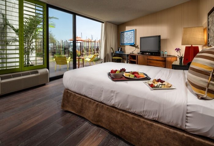 Hotel Maya A Doubletree Hotel room with fruit and cheese plates on bed. Gay-friendly hotel with patio views. Great for gay travel.