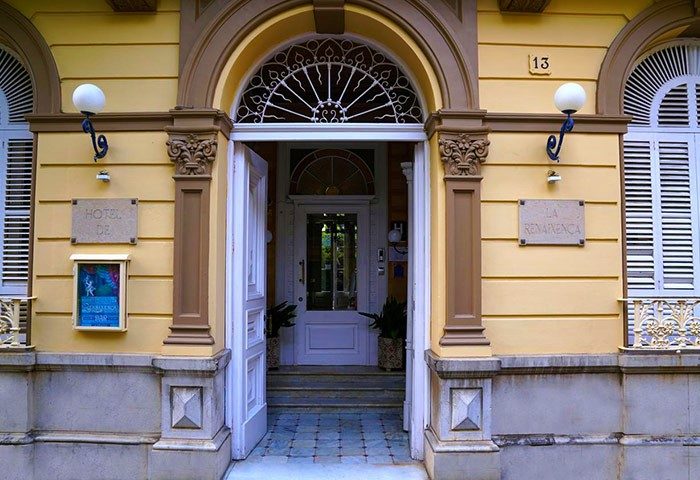 Hotel Medium Renaixenca entrance. Gay-friendly hotel with architectural details, arched doorway, and yellow facade. A great choice for gay travel.