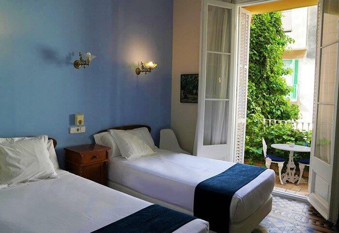 Hotel Medium Renaixenca gay-friendly room with twin beds and balcony. A great option for gay travelers seeking comfort and style.