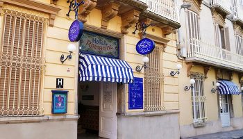 Hotel Medium Romantic exterior. Gay-friendly hotel with blue and white striped awning. Facade of the Hotel Romantic, a welcoming spot for gay travelers.