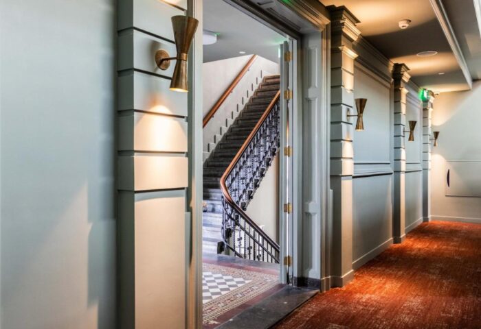 Hotel Mercier's hallway with vintage sconces and a view of the staircase. This gay-friendly hotel offers stylish accommodations for gay travelers.