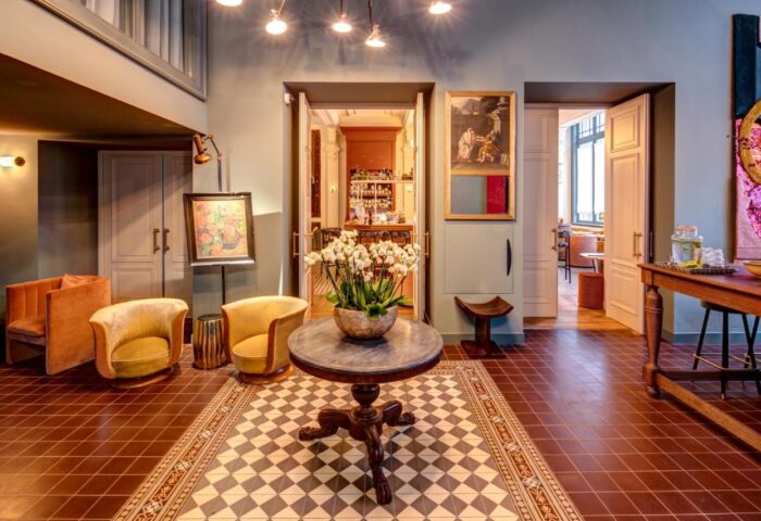 Hotel Mercier lobby, gay-friendly space. Elegant design with chairs, table, and artwork. Inviting interior for gay travelers. Amsterdam hotel.