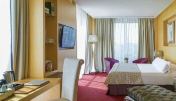 Hotel MiM Sitges gay-friendly hotel room. Modern design with desk, tv, bed, and seating area. Gay travel in Sitges, Spain.