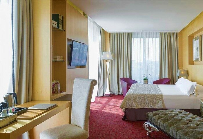 Hotel MiM Sitges gay-friendly hotel room. Modern design with desk, tv, bed, and seating area. Gay travel in Sitges, Spain.