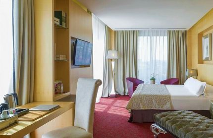 Hotel MiM Sitges gay-friendly hotel room. Modern design with desk, tv, bed, and seating area. Gay travel in Sitges, Spain.