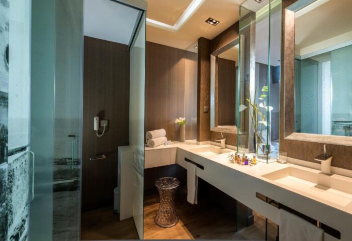 Hotel MiM Sitges gay-friendly hotel bathroom. Modern design with double sinks, shower, and stylish decor. Gay travel in Sitges.