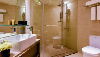 Hotel Midtown Richardson gay-friendly bathroom with glass shower, sink, and toilet. Modern design in this hotel for gay men travelers.