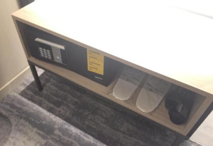 Hotel Midtown Richardson safe and slippers. Gay-friendly hotel room detail showing amenities for a comfortable stay.