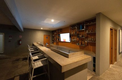 Hotel Mio Vallarta Adults Only bar. Gay-friendly hotel bar with liquor shelves, TV, and stools. Ideal for gay travel in Puerto Vallarta.