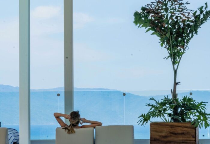 Woman relaxing at Hotel Mio Vallarta Adults Only, a gay-friendly hotel. Poolside view of ocean and mountains. Serene travel for gay men.