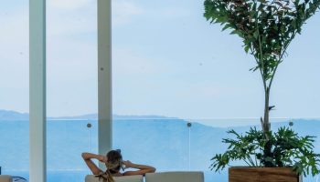 Woman relaxing at Hotel Mio Vallarta Adults Only, a gay-friendly hotel. Poolside view of ocean and mountains. Serene travel for gay men.