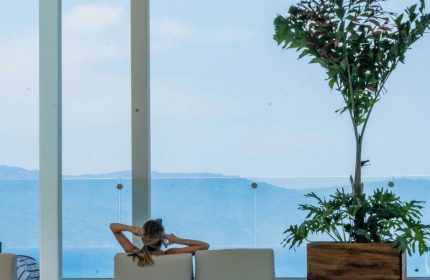 Woman relaxing at Hotel Mio Vallarta Adults Only, a gay-friendly hotel. Poolside view of ocean and mountains. Serene travel for gay men.