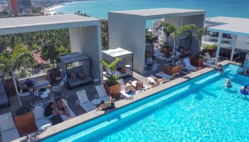 Rooftop pool at Hotel Mio Vallarta, an adults-only, gay-friendly hotel in Puerto Vallarta. People relax by the pool with ocean views.