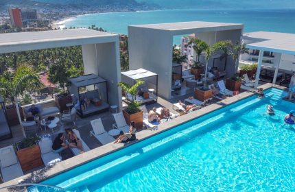 Rooftop pool at Hotel Mio Vallarta, an adults-only, gay-friendly hotel in Puerto Vallarta. People relax by the pool with ocean views.
