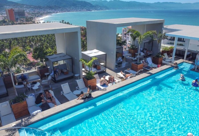 Rooftop pool at Hotel Mio Vallarta, an adults-only, gay-friendly hotel in Puerto Vallarta. People relax by the pool with ocean views.