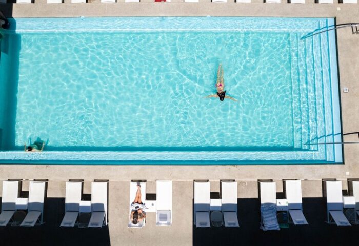 Aerial view of Hotel Mio Vallarta Adults Only pool. A gay-friendly hotel with clear turquoise water and white lounge chairs.