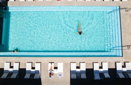 Aerial view of Hotel Mio Vallarta Adults Only pool. A gay-friendly hotel with clear turquoise water and white lounge chairs.