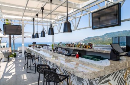 Hotel Mousai Cancun adults-only all-inclusive gay-friendly rooftop bar. Ocean view, stylish bar stools, and liquor selection.