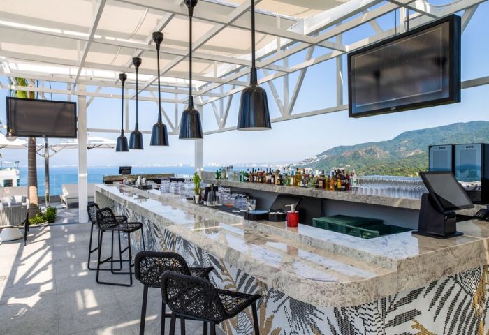 Hotel Mousai Cancun adults-only all-inclusive gay-friendly rooftop bar. Ocean view, stylish bar stools, and liquor selection.