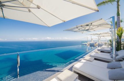 Hotel Mousai Cancun adults-only all-inclusive gay-friendly resort. Infinity pool, ocean view, lounge chairs, and umbrellas for a luxurious getaway.