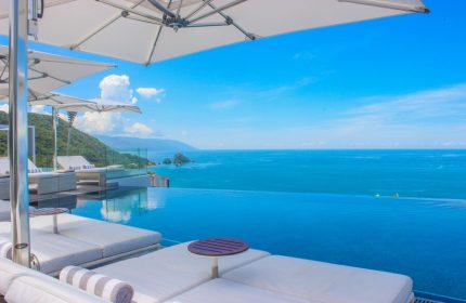 Hotel Mousai Cancun adults-only all-inclusive gay-friendly hotel. Infinity pool, ocean view, lounge chairs, and umbrellas. Perfect for gay travel.