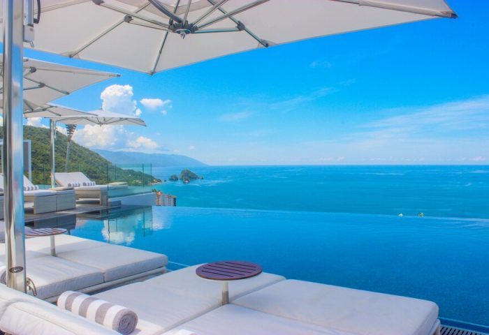 Hotel Mousai Cancun adults-only all-inclusive gay-friendly hotel. Infinity pool, ocean view, lounge chairs, and umbrellas. Perfect for gay travel.