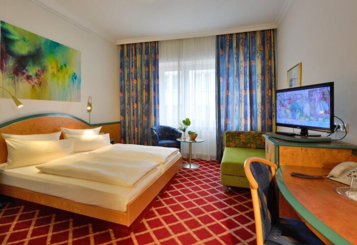 Hotel Müller Munich room. Gay-friendly hotel with double bed, desk, TV, and colorful decor. A comfortable stay for gay travelers in Munich.