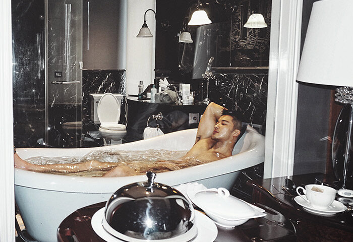 Man relaxing in tub at Hotel Muse Bangkok Langsuan MGallery Collection, a gay-friendly hotel with luxury amenities and stylish design.