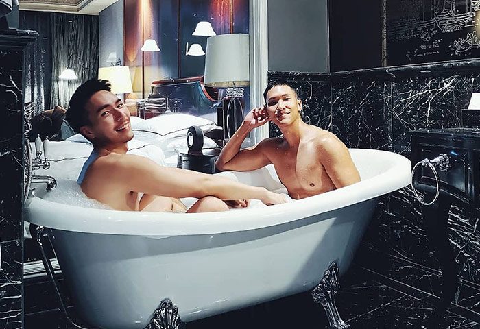 Gay couple in a bubble bath at Hotel Muse Bangkok Langsuan, MGallery Collection. Gay-friendly hotel, luxury travel.