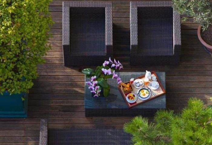 Hotel Napoleon's pet-friendly patio. Outdoor seating, breakfast tray, and plants create a relaxing atmosphere at this gay-friendly hotel.