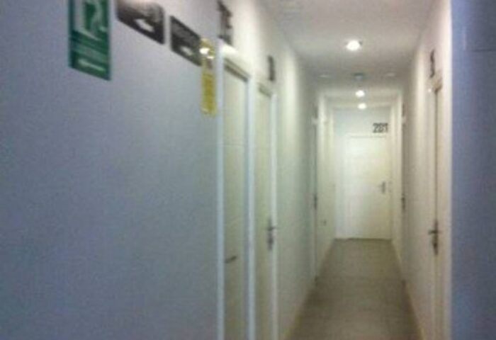 Hotel Natursun's hallway. Gay-friendly hotel featuring a long, brightly lit corridor with room doors. Great option for gay men travelers.