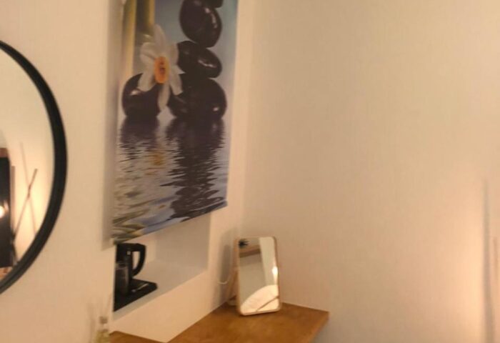 Hotel Nazos Mykonos Town room detail. Gay-friendly hotel's interior with a vanity, mirror, and zen-themed art. Mykonos gay travel.