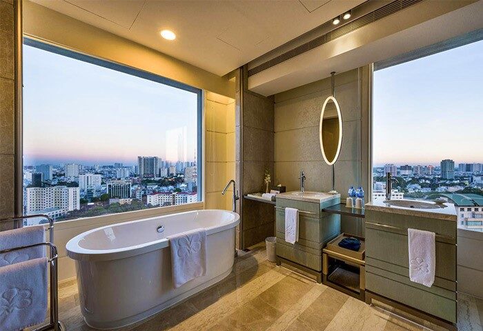 Gay-Friendly Hotel Nikko Saigon bathroom with city view. Bathtub, sinks, mirror. Luxury gay travel accommodations in Ho Chi Minh City.