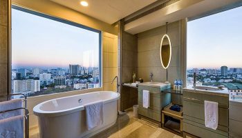 Gay-Friendly Hotel Nikko Saigon bathroom with city view. Bathtub, sinks, mirror. Luxury gay travel accommodations in Ho Chi Minh City.