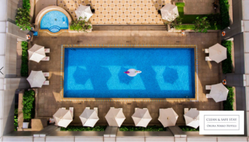 Hotel Nikko Saigon gay-friendly hotel pool aerial view. Swimming pool with lounge chairs and umbrellas. Saigon hotel for gay travelers.