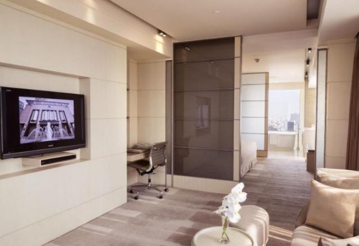Hotel Nikko Saigon gay-friendly room. Modern interior with TV, desk, and partial view of the bathroom. Comfortable stay in Saigon.