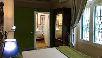 Hotel Noucentista gay-friendly room. Bedroom view with bed, bathroom, wardrobe, and window. Gay travel advice for Noucentista hotels.