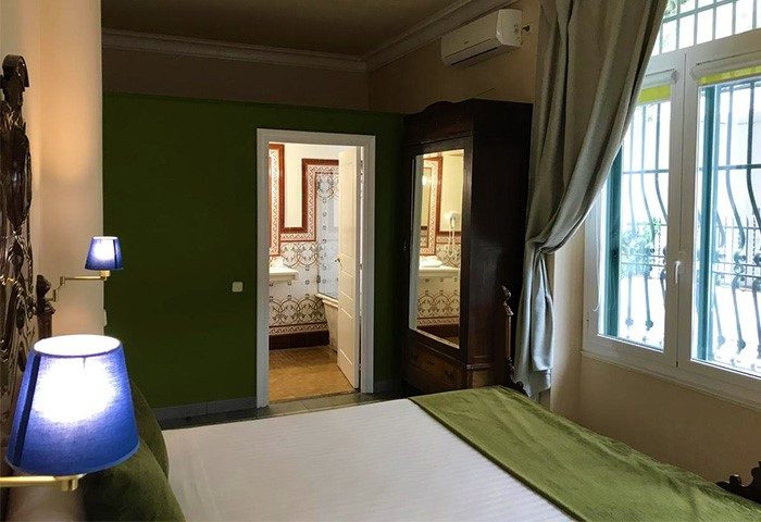 Hotel Noucentista gay-friendly room. Bedroom view with bed, bathroom, wardrobe, and window. Gay travel advice for Noucentista hotels.